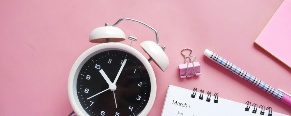 white and pink analog alarm clock